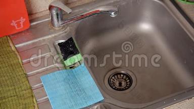 一个女人在水槽里洗脏盘子。 打扫公寓